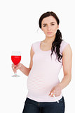 Pregnant young woman holding alcoholic drink and cigarette