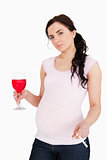 Pregnant brunette holding alcoholic drink and cigarette