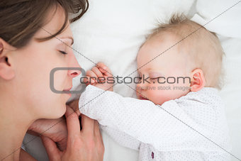 Peaceful woman lying on a bed with her daughter