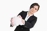 Upset businesswoman holding an empty piggy bank