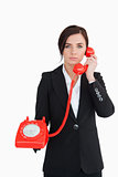 Business woman using a red dial telephone