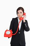 Businesswoman using a red dial telephone