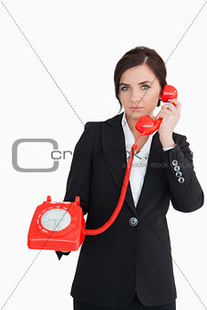 Businesswoman using a red dial telephone
