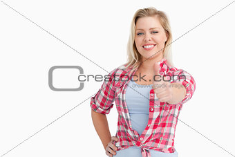 Happy blonde woman placing her thumbs up