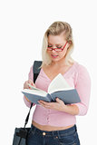 Serious woman reading a novel while wearing glasses