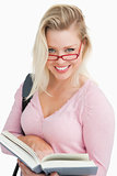 Happy blonde woman looking over her red glasses