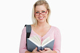 Happy woman holding a book while standing