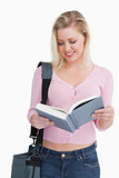 Smiling blonde woman reading a novel