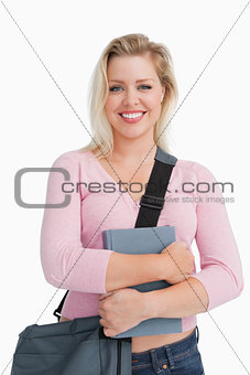 Happy blonde woman holding a school book