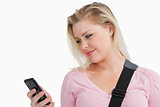 Blonde woman standing while sending a text
