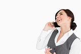 Brunette laughing while making a call with her smartphone