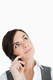 Brunette in suit looking up while phoning