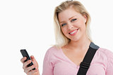 Blonde woman holding her mobile phone while writing a text