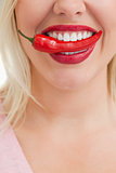 Happy woman placing a red chili in her mouth
