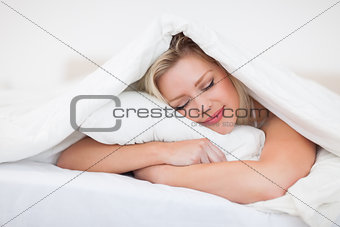 Blonde resting while embracing her pillow
