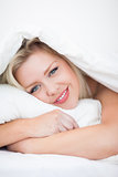 Young blue eyed woman embracing a pillow