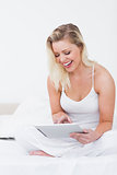 Blonde laughing while using an ebook