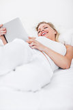 Blonde laughing while using an ebook reader