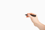 Fingers holding a black felt pen while pointing a blank space