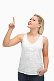 Cheerful blonde woman pointing her finger up
