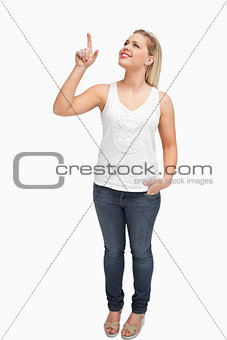 Joyful blonde woman pointing her finger up