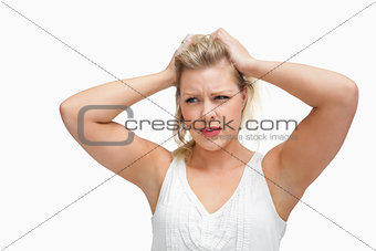 Serious blonde woman placing her hands on her head