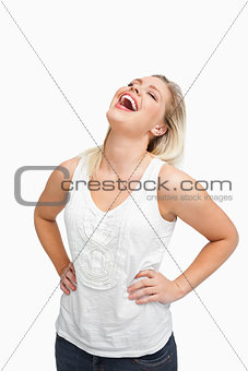 Blonde woman laughing while placing her hands on her hips