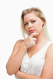 Thoughtful blonde woman placing her hand on her chin