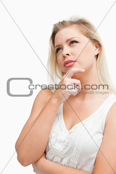 Thoughtful blonde woman looking up while standing