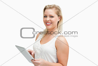 Cheerful blonde woman holding her tablet computer