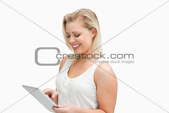 Smiling blonde woman using her tablet computer