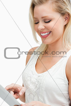 Joyful blonde woman looking at her tablet computer