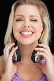 Happy blonde woman proudly holding her headphones