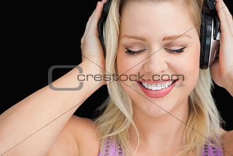 Smiling blonde woman wearing her headphones