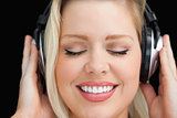 Cheerful woman closing her eyes while listening to music