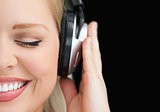 Joyful woman closing her eyes while listening to music