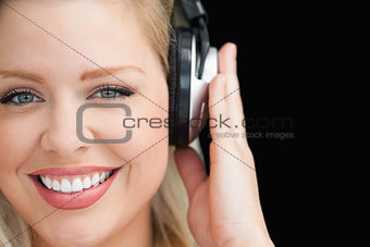 Smiling blonde woman listening to music through headphones