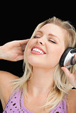 Joyful blonde woman listening to music with headphones