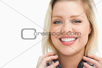Happy blonde woman holding her headphones