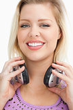 Smiling blonde woman standing while holding headphones