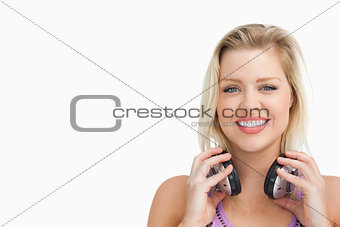 Peaceful blonde woman holding her headphones