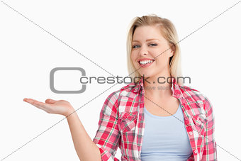Blonde woman beaming while placing her hand palm up