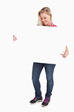 Smiling blonde woman pointing at a blank sign