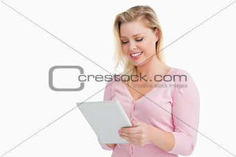 Blonde woman standing while using her touchscreen