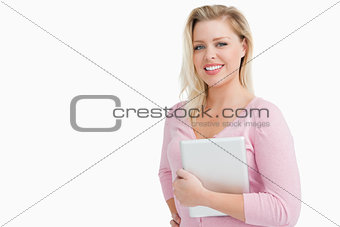 Joyful blonde woman holding her tablet computer
