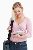 Happy blonde woman holding her tablet pc