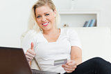 Woman with a credit and using a laptop