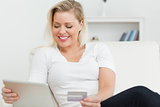 Casual woman sitting on a sofa using a tablet pc