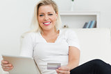 Casual woman with tablet pc and a credit card