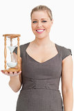 Woman smiling while holding a hourglass